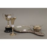 A silver mustard pot, a silver bud vase, a small silver trophy cup and a silver backed mirror (2.