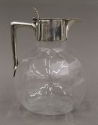 A silver lidded glass claret jug,