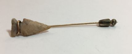 A bar brooch set with a Stone Age arrowhead