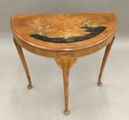 An early 20th century chinoiserie decorated demi lune table