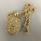 An ornate Victorian silver gilt (tested) locket on a gilt metal chain