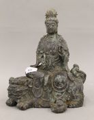 A bronze model of Guanyin seated on a dog-of-fo