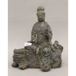 A bronze model of Guanyin seated on a dog-of-fo