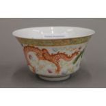 A Chinese porcelain bowl, decorated with a dragon and a phoenix chasing a flaming pearl,