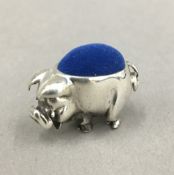 A silver pin cushion in the form of a pig