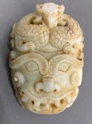 A jade buckle carved as a mythical beast mask