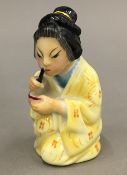 A Royal Worcester porcelain candle snuffer formed as an Oriental woman