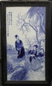 A large Chinese blue and white porcelain plaque, depicting figures before a river with calligraphy,