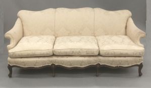 A late 19th/early 20th century mahogany framed three seat upholstered settee The overstuffed shaped