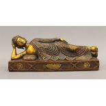 A bronze model of buddha laying down. 30.5 cm long; 12 cm high; 10 cm deep.