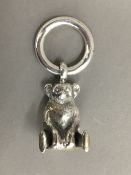 A silver rattle in the form of a teddy bear