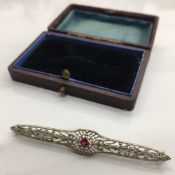 An Art Deco 10 K white gold and ruby bar brooch in fitted box (2.