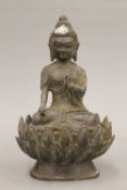 A bronze model of a Buddha seated on a lotus flower