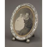 An antique sterling silver photograph frame on ball feet