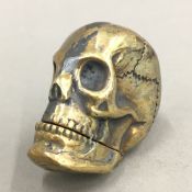 A brass vesta in the form of a skull