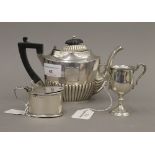 A small silver teapot, a silver mustard pot and a small silver trophy cup (9.