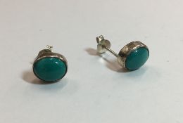 A pair of silver and turquoise earrings