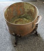 A Victorian copper pot in a wrought iron stand