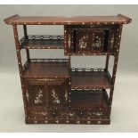 A Chinese mother-of-pearl inlaid hardwood side cabinet. 122 cm high, 114 cm wide, 37 cm deep.