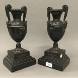 A pair of patinated bronze urn form garnitures