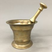 An 18th century bronze pestle and mortar