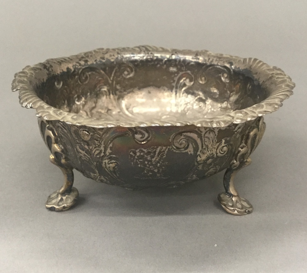 A silver embossed three footed bowl (4.