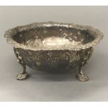 A silver embossed three footed bowl (4.