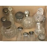 A collection of various silver topped scent bottles and other glass scent bottles and jars