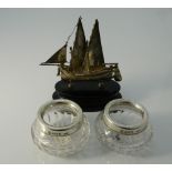 A Chinese silver model of a junk and two silver mounted glass salts