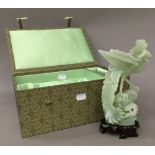 A pale green jade bird, with wooden stand,