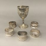 Five silver napkin rings and a small embossed silver cup (6.7 troy ounces.