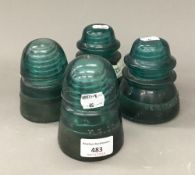 Four vintage green glass electricity isolators