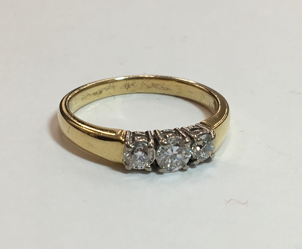 An 18 ct gold diamond three stone ring (3.