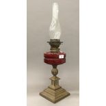 A Victorian brass oil lamp with ruby glass reservoir