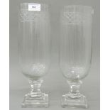 A pair of small glass hurricane lamps