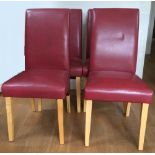 A set of four modern red leather upholstered dining chairs