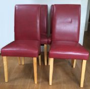 A set of four modern red leather upholstered dining chairs