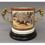An Aynsley porcelain Glorious Goodwood twin handled cup on stand