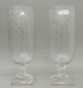 A pair of large glass hurricane lamps