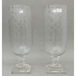 A pair of large glass hurricane lamps