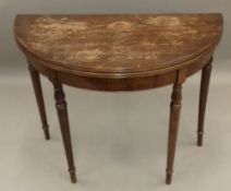 A mahogany demi lune card table