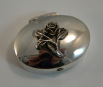 A silver oval pill box