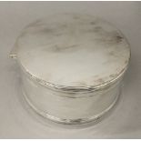 A cylindrical silver plated box
