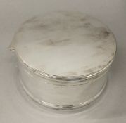 A cylindrical silver plated box