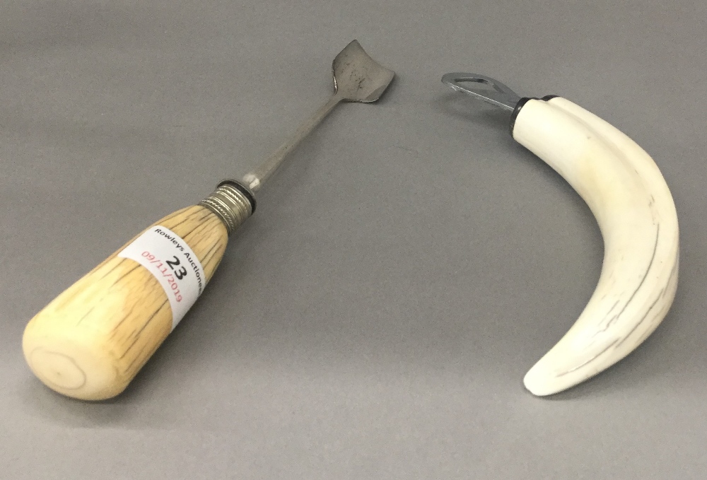 A 19th century ivory handled cheese scoop and a boar tusk bottle opener