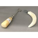A 19th century ivory handled cheese scoop and a boar tusk bottle opener