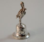 A silver bell mounted with a stork. 4 cm high.