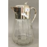 A large silver plate mounted clear glass jug