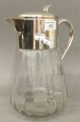 A large silver plate mounted clear glass jug