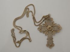 A silver filigree cross on chain